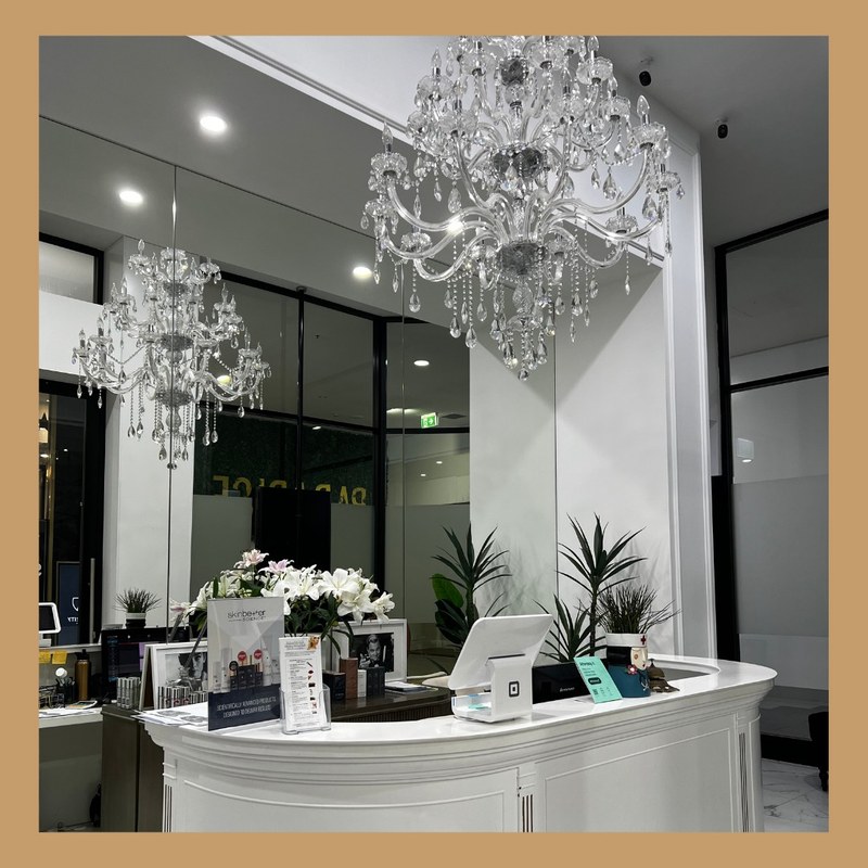 Reception and chandeliers inside All About Face Aesthetics.